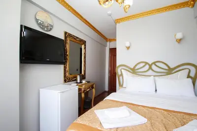 a bedroom with a bed with a mirror and a tv at Californiacityhotel in Istanbul