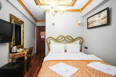 a bedroom with a bed and a desk and a television at Californiacityhotel in Istanbul