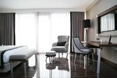 a bedroom with a bed and a desk and chairs at Ramada Hotel & Suites Sisli in Istanbul