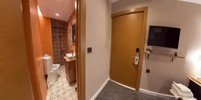 a bathroom with a toilet and a television on the wall at Taksim REXXEE Istanbul Istiklal Hotel in Istanbul