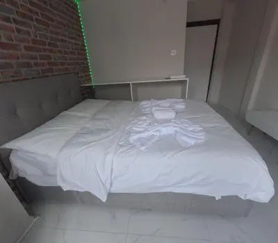 a large white bed in a room with a brick wall at lastbest hotel in Istanbul