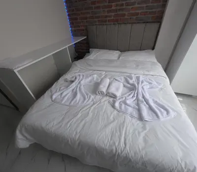 an unmade bed in a room with a brick wall at lastbest hotel in Istanbul