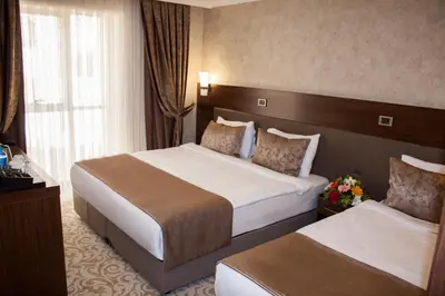 a hotel room with two beds and a window at Gorukle Oruc Hotel in Bursa