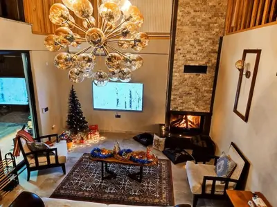 a living room with a christmas tree and a chandelier at Eviniz rahatlığında, eşsiz doğa manzaralı dağ evi in Gölcük