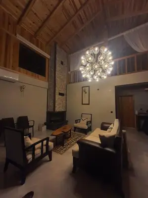 a living room with a chandelier and a couch and chairs at Eviniz rahatlığında, eşsiz doğa manzaralı dağ evi in Gölcük