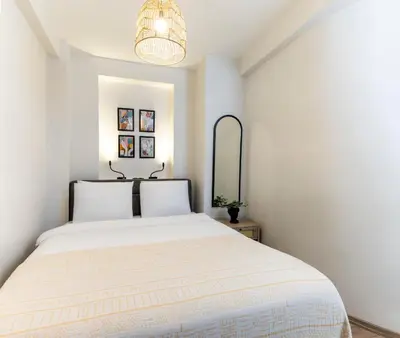 a bedroom with a white bed and a mirror at Mariposa Rooms Taksim in Istanbul