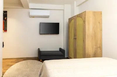 a bedroom with a bed and a chair and a tv at Mariposa Rooms Taksim in Istanbul