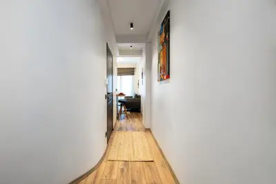 a hallway with a white wall and a wooden floor at Mariposa Rooms Taksim in Istanbul