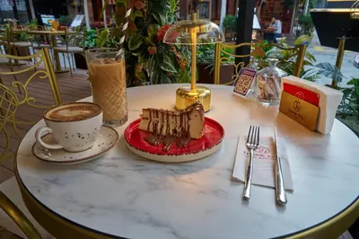 a table with a piece of cake and a cup of coffee at Thank You Hotel Sultanahmet in Istanbul