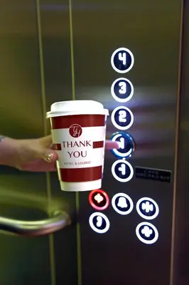a person holding a cup of coffee in front of a machine at Thank You Hotel Sultanahmet in Istanbul