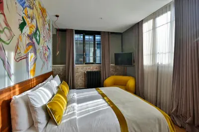 a bedroom with a large bed and a yellow chair at Hotel The Public - Special Category in Istanbul