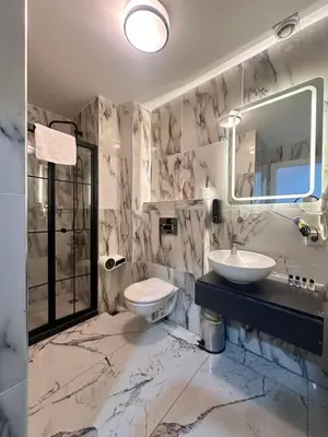 a bathroom with a sink and a toilet and a mirror at Taksim Cetinkaya Suite in Istanbul