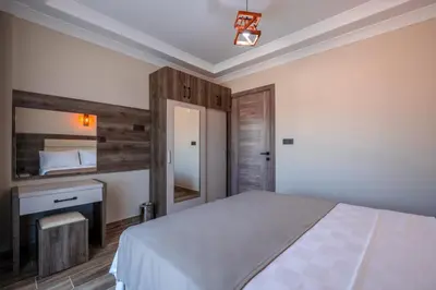 a bedroom with a bed and a desk and a mirror at Avsa Artemis Hotel in Avsa Adasi