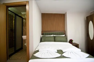 a bedroom with a bed with white sheets and green pillows at Aurora Eco Hotel in Istanbul