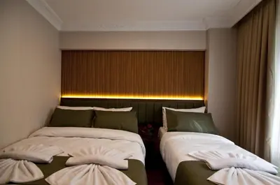 two beds in a hotel room with a window at Aurora Eco Hotel in Istanbul