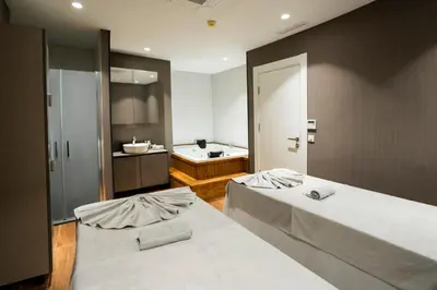 two beds in a room with a bathroom at Riva Hotel Nişantaşı in Istanbul