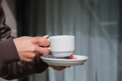a person is holding a cup on a plate at No25 Suites Nisantasi in Istanbul