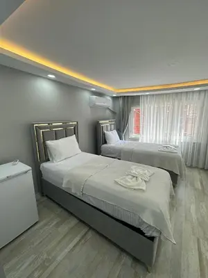 a bedroom with two beds and a window at IMMOR AKKUS HOTEL in Istanbul