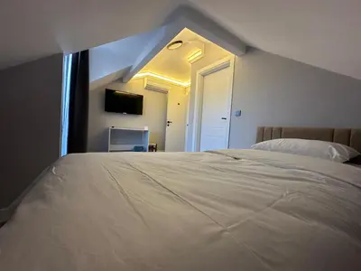 a bedroom with a large white bed and a window at ASLAN AİRPORT Hotel in Arnavutköy