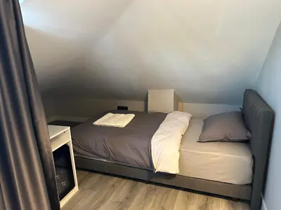 a small bedroom with a bed and a night stand at ASLAN AİRPORT Hotel in Arnavutköy