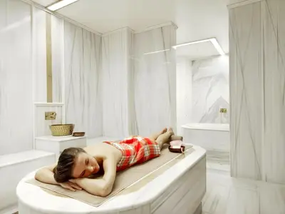 a young girl laying on a bed in a bathroom at Sedef Apartments Pera in Istanbul