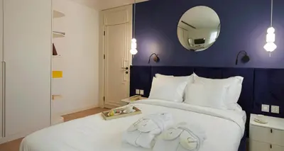 a bedroom with a large white bed with a mirror at G Residences Gayrettepe in Istanbul