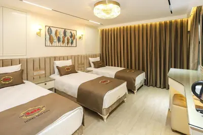 a hotel room with three beds and a chandelier at Safa Hotel Old City in Istanbul