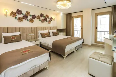 a hotel room with two beds and a table at Safa Hotel Old City in Istanbul