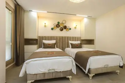 a bedroom with two beds and a clock on the wall at Safa Hotel Old City in Istanbul
