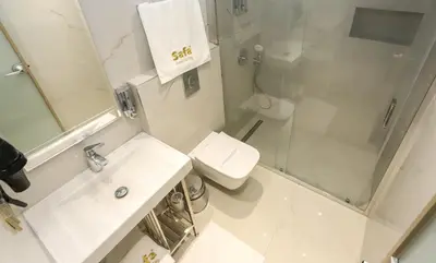 a white bathroom with a toilet and a shower at Safa Hotel Old City in Istanbul