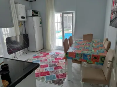 a kitchen with a dining room table with a mosaic table cloth at Villaferhat mavi in Karacaköy