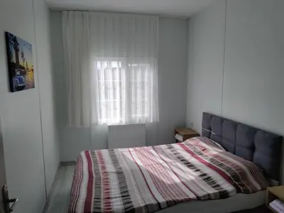 a bedroom with a bed with a striped blanket and a window at Villaferhat mavi in Karacaköy