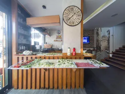 a food counter with a large clock on the wall at Sirkeci Esen Apart in Istanbul