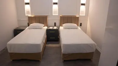 two beds in a small room with lights above them at Global Termal Hotel in Çekirge