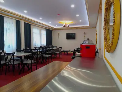 a restaurant with tables and chairs in a room with a red carpet at Global Termal Hotel in Çekirge