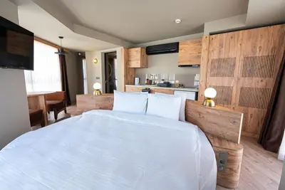a bedroom with a large white bed and a kitchen at Tare Houses in Istanbul