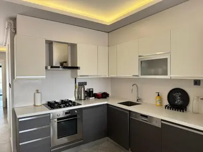 a kitchen with white cabinets and stainless steel appliances at Bomonti 42 Suites in Istanbul