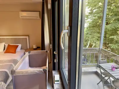 a room with a bed and a balcony with a window at Bomonti 42 Suites in Istanbul