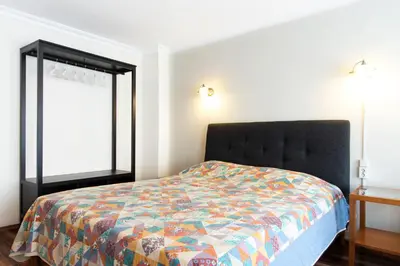 a bedroom with a bed with a colorful comforter and two windows at An Unforgettable Experience in Istanbul