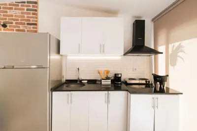 a kitchen with white cabinets and a black counter top at Stylish Duplex House with a Special Terrace in Istanbul