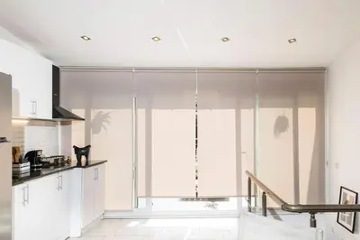 a kitchen with white cabinets and a large window at Stylish Duplex House with a Special Terrace in Istanbul