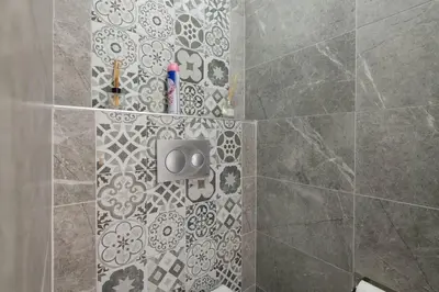 a bathroom with a shower with a tile wall at Cute 1 Room w AC 300 meters to Istiklal Street in Istanbul
