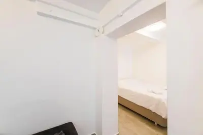 a bedroom with white walls and a bed at Beautiful 2BR House w/AC 400meters Taksim Square in Istanbul
