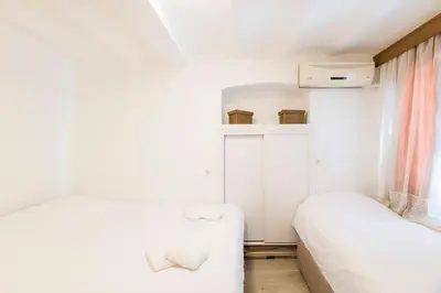 a small bedroom with two beds and a window at Beautiful 2BR House w/AC 400meters Taksim Square in Istanbul
