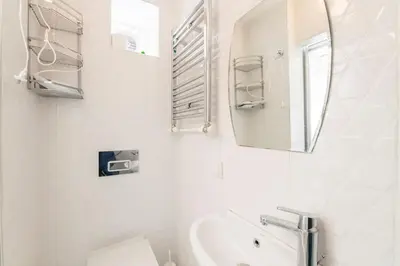 a white bathroom with a sink and a mirror at Beautiful 2BR House w/AC 400meters Taksim Square in Istanbul