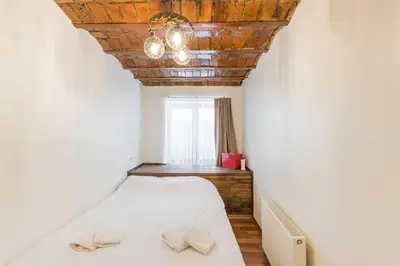 a bedroom with a white bed with a wooden ceiling at Beautiful 1 Br Apt. w/AC 400 meters Taksim Square in Istanbul