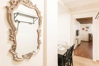 a large gold mirror hanging on a wall next to a dining room at Beautiful 1 Br Apt. w/AC 400 meters Taksim Square in Istanbul