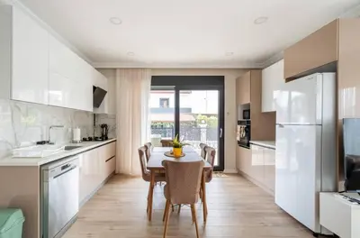 a kitchen with a table and chairs in a room at Stylish 2BR and 3BR Izmit Apartments- Chic & Cozy in Çavuşçiftliği