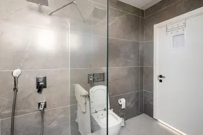 a bathroom with a toilet and a shower at Stylish 2BR and 3BR Izmit Apartments- Chic & Cozy in Çavuşçiftliği