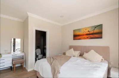 a bedroom with a bed and a desk with a picture on the wall at Stylish 2BR and 3BR Izmit Apartments- Chic & Cozy in Çavuşçiftliği